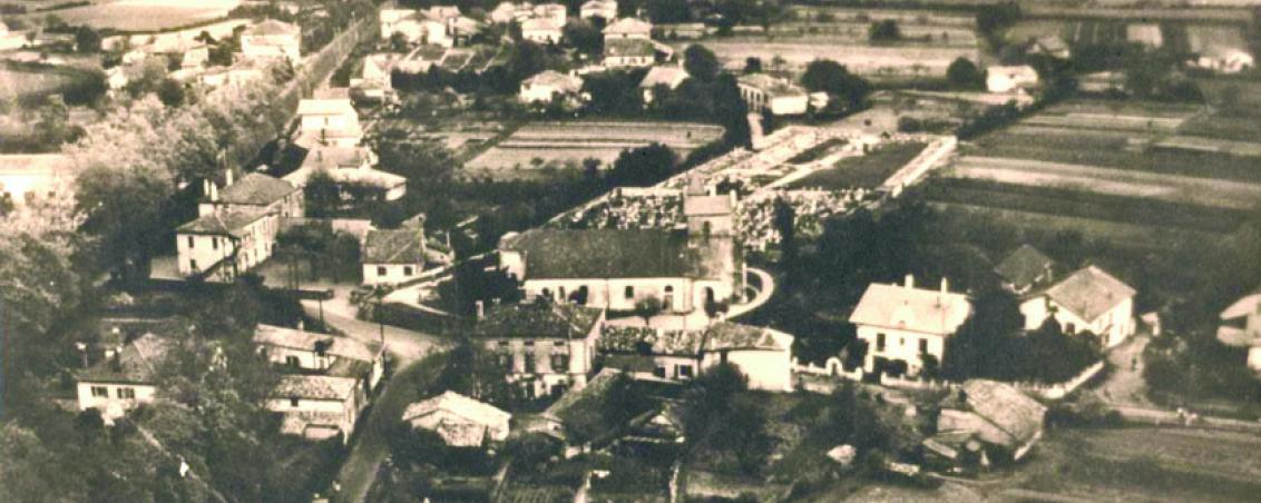 Église Saint Vincent et actuelle place Dous Haous au début des années 1950. Dans la partie supérieure gauche, la RD810 (ex RN10) bordée de platanes