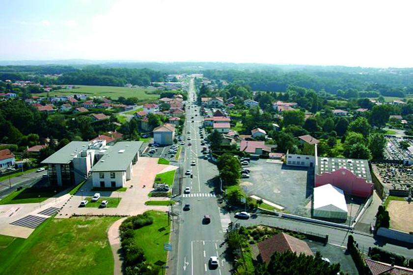 Vue aérienne de 2004, direction Ondres Bayonne. Au centre, la RD810, sur la partie gauche, le nouvel Hôtel de Ville inauguré en 2004, à gauche, la salle Jacques Duclos et le fronton